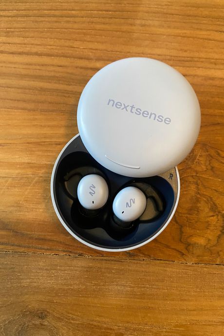 A pair of earbuds in a case on a table.
