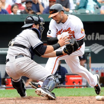BALTIMORE, MD- SEPTEMBER 8: Nick Markakis #21 of the Baltimore Orioles collides with catcher Francisco Cervelli of the New York Yankees while trying unsuccessfully to score in the 7th inning of a game against the New York Yankees at Oriole Park at Camden Yards on September 8, 2011 in Baltimore, Maryland. The Orioles beat the Yankees 5-4 in ten innings. (Photo by Steve Ruark/Getty Images)