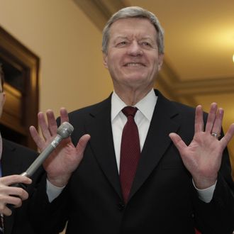 Super committee member Senator Max Baucus (D-MT) gestures to the media as he arrives at the meeting between Republican and Democratic members of the 