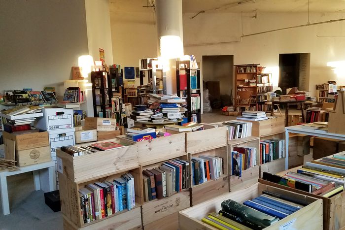 Books in crates and bookshelves and tables spread across a lobby.