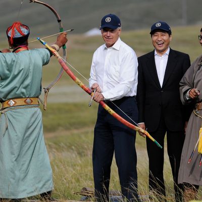 US Vice President Joe Biden (C) tries his hand at archery as Mongolian Prime Minister Sukhbaatar Batbold (2nd R) laughs during a mini Naadam staged in Biden's honour in Ulan Bator on August 22, 2011. Biden on August 22 hailed the United States' growing ties with Mongolia on a rare visit by an American leader to the Asian nation, which is opening up its vast coal reserves to foreign investors. AFP PHOTO / GOH CHAI HIN (Photo credit should read GOH CHAI HIN/AFP/Getty Images)