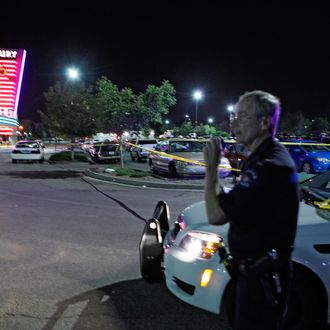 An Aurora Police officer talks on his radio outside of the Century 16 theater at Aurora Mall where as many as 14 people were killed and many injured at a shooting at the Century 16 movie theatre in Aurora, Colo., Friday, July 20, 2012. (AP Photo/Ed Andrieski)