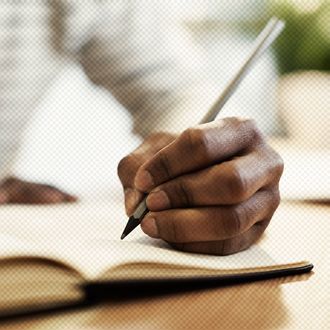 Man's hand drawing in a notebook