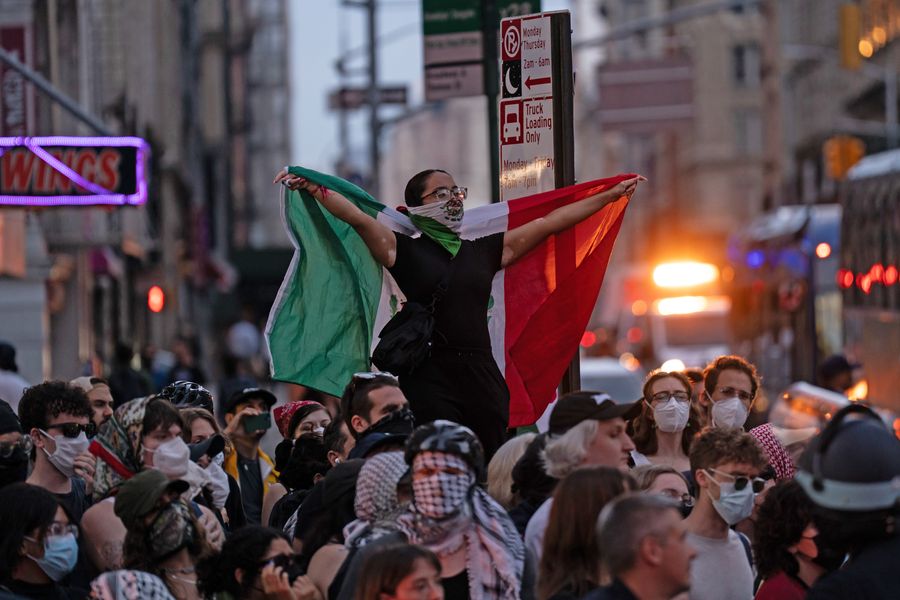 A person holds a Mexican flag at a June 10 protest against ICE and deportations outside of federal buildings downtown.