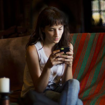 Woman in cafe texting with mobile phone