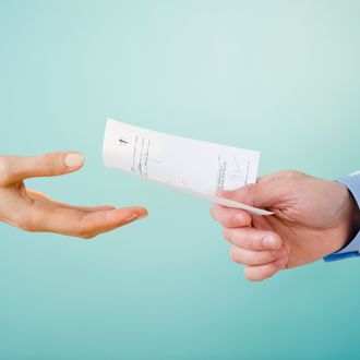 Close up of doctor's hand giving prescription to patient, studio shot