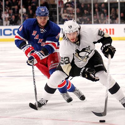 Kris Letang #58 of the Pittsburgh Penguins skates with the puck in front of Marian Gaborik #10 of the New York Rangers