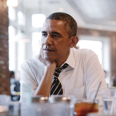 U.S. President Barack Obama listens during a meeting with young citizens at Columbia Height's restaurant The Coupe on January 10, 2014 in Washington, DC.