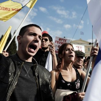 Protesters chant slogans during a massive anti-austerity rally in front of the Greek parliament in Athens on November 1, 2014. 