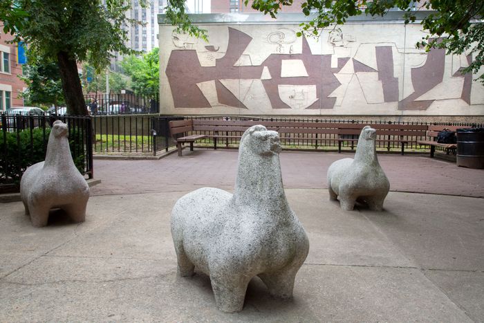 A group of abstract, stocky horse statues made from concrete