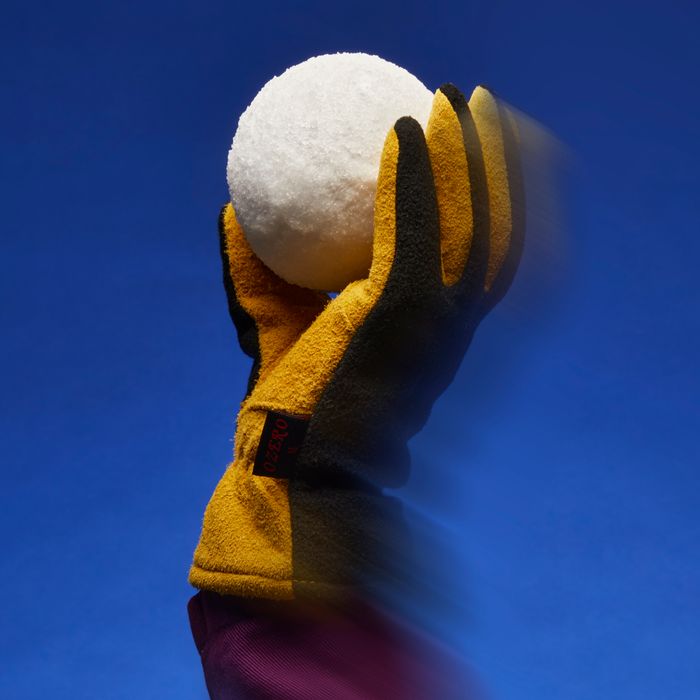 Women's winter glove gripping a snow ball