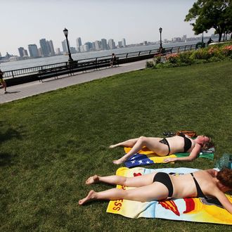 Women sunbathe in Battery Park City on the banks of the Hudson River June 8, 2011 in New York City. An early summer heat wave hit the city with temperatures around 93 degrees today and forecast to hit a record 97 degrees tomorrow.