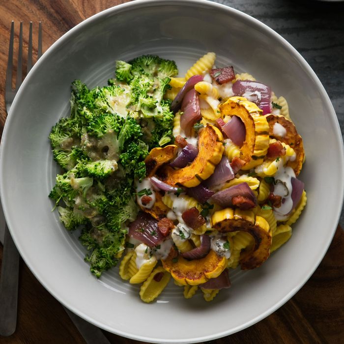 A bowl with plum, goat cheese, and farro; malloreddus pasta with sage-roasted delicata squash.