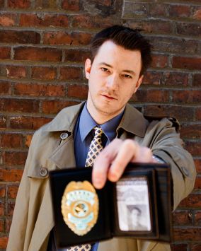 Detective showing his badge and ID (focus on the face, not the badge), a look of routine on his face. Background is a red brick wall. Portrait image on the ID card was shot by me and is available on iStockphoto. An alternative to this image, with the badge in focus is also available.