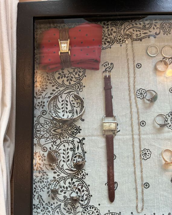 Photo of a glass case displaying vintage jewelry and watches at the Buck Mason Soho store.