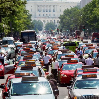 Washington, DC, taxi drivers park their cars and honk the horn in protest on Pennsylvania Avenue, bringing street traffic to a stop as they demand an end to ride sharing services such as Uber X and Lyft on June 25, 2014, in Washington, DC. (Photo credit should read PAUL J. RICHARDS/AFP/Getty Images)