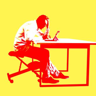 man is bent over tablet.Bad sitting posture at work