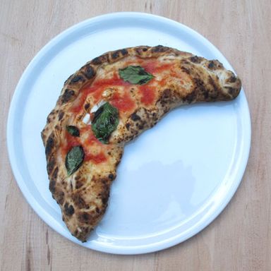 Calzone with mozzarella, ricotta, ham, tomato, basil.