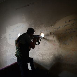 A Syrian rebel observes the movement of regime forces as he takes position inside a building in the Saif al-Dawla district of the northern Syrian city of Aleppo on April 5, 2013. The UN is hiking its estimates of people trapped in Syria after fleeing their homes, saying some four million are now displaced inside the country and in dire need of international help. 