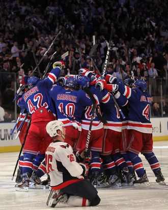 NEW YORK, NY - MAY 07: Marc Staal #18 of the New York Rangers celebrates with his teammates after scoring the winning goal in overtime against Braden Holtby #70 of the Washington Capitals as Matt Hendricks #26 of the Washington Capitals slides to the ice after Game Five of the Eastern Conference Semifinals during the 2012 NHL Stanley Cup Playoffs at Madison Square Garden on May 7, 2012 in New York City. The New York Rangers defeated the Washington Capitals in overtime 2-3. (Photo by Bruce Bennett/Getty Images)