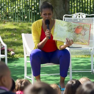 First Lady Michelle Obama reads a book to children during the 2012 White House Easter Egg Roll on the South Lawn of the White House in Washington, DC, April 9, 2012.