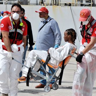 A woman rescued at sea receives medical assistance as the Italian Navy ship 