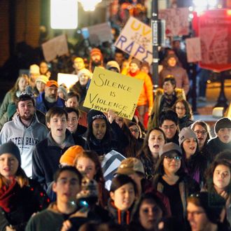 Protestors carry signs and chant slogans as they march along University Avenue on The Corner, a popular nighttime destination with bars and restaurants adjacent to the University of Virginia, Saturday night, Nov. 22, 2014, in Charlottesville, Va. The protest, the most well-attended of several throughout the day, was in response to the university's reaction to an alleged sexual assault of a student revealed in a recent Rolling Stone article. (AP Photo/The Daily Progress, Ryan M. Kelly)