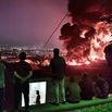 People observe fire and smoke from an Israeli attack on the Shahran oil depot on June 15  in Tehran