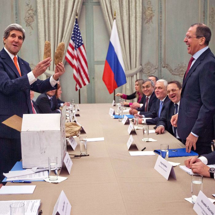 US Secretary of State John Kerry (L) holds Idaho potatoes as a gift for Russia's Foreign Minister Sergey Lavrov (2R) before the start of their meeting at the US Ambassador's residence in Paris, on January 13, 2014. Kerry, his Russian counterpart Sergei Lavrov and UN-Arab League envoy on Syria will meet for talks aimed at finalising preparations for hoped-for peace talks between Bashar al-Assad's regime and the opposition National Coalition. AFP PHOTO/POOL/PABLO MARTINEZ MONSIVAIS (Photo credit should read PABLO MARTINEZ MONSIVAIS/AFP/Getty Images)