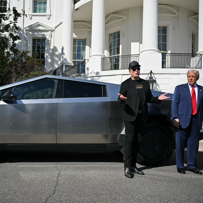 Elon Musk and Donald Trump stand in front of a Tesla Cybertruck