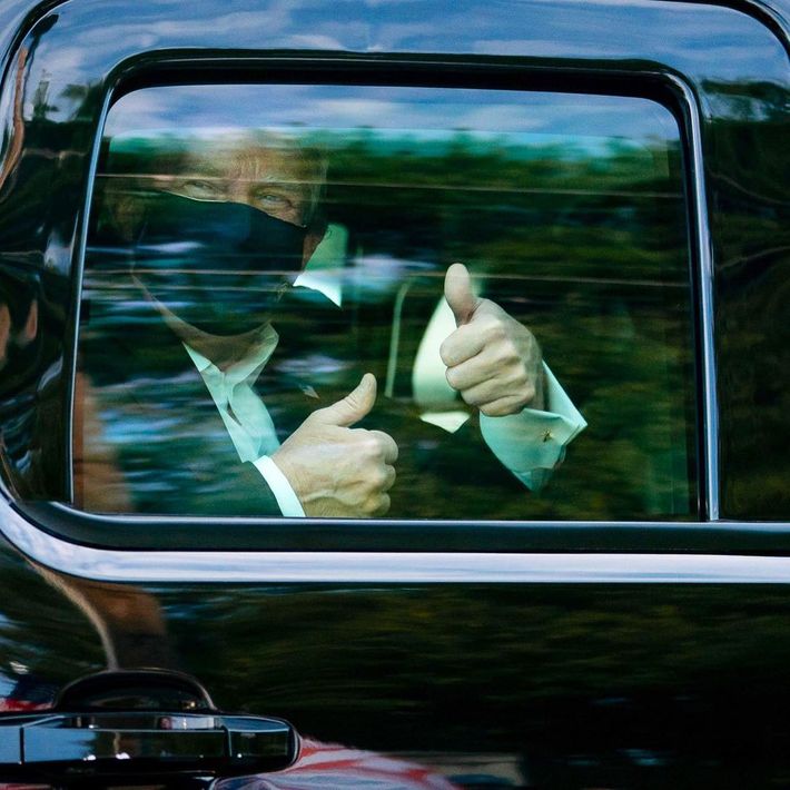 President Donald Trump gives a thumbs up from the back of an SUV while greeting crowds outside Walter Reed Medical center following his COVID hospitalization.