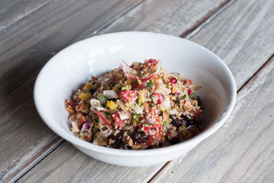 Cypriot salad with cracked bulgur wheat, smoked almond, pistachio, Medjool date, pomegranate, peppers, onion, cucumber, and cilantro.