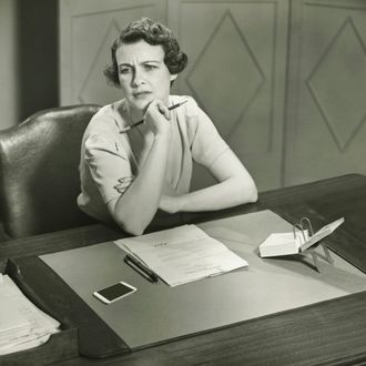 Worrying woman sitting at desk in office