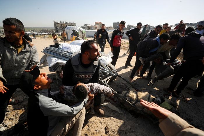 Palestinians hold the body of journalist Hossam Shabat, who was killed by in an Israeli strike, according to medics, in the northern Gaza Strip