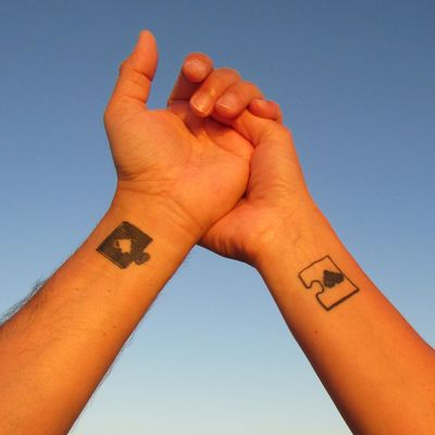 A couple with matching puzzle piece tattoos.