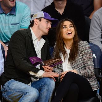 Ashton Kutcher (L) and Mila Kunis attend basketball games between the New Orleans Pelicans and the Los Angeles Lakers at Staples Center on March 4, 2014 in Los Angeles, California.