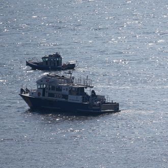 NYPD divers ride a boat on the Hudson River near the site of small plane crash, Saturday, May 28, 2016, in North Bergen, N.J. A World War II vintage P-47 Thunderbolt aircraft crashed into the river Friday, May 27 killing its pilot. (AP Photo/Julio Cortez)