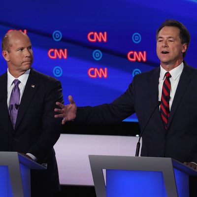 Democratic presidential candidate Montana Gov. Steve Bullock (R) speaks while former Maryland congressman John Delaney listens during the Democratic Presidential Debate at the Fox Theatre July 30, 2019 in Detroit, Michigan.