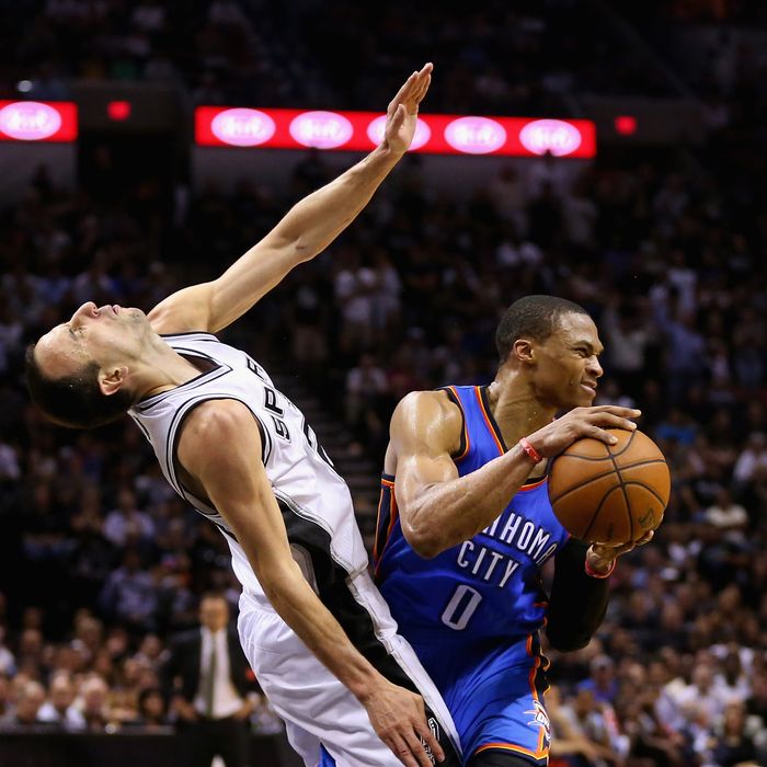 Manu Ginobili #20 of the San Antonio Spurs falls to the court after colliding with Russell Westbrook #0 of the Oklahoma City Thunder in the second half during Game Five of the Western Conference Finals of the 2014 NBA Playoffs at AT&T Center on May 29, 2014 in San Antonio, Texas.