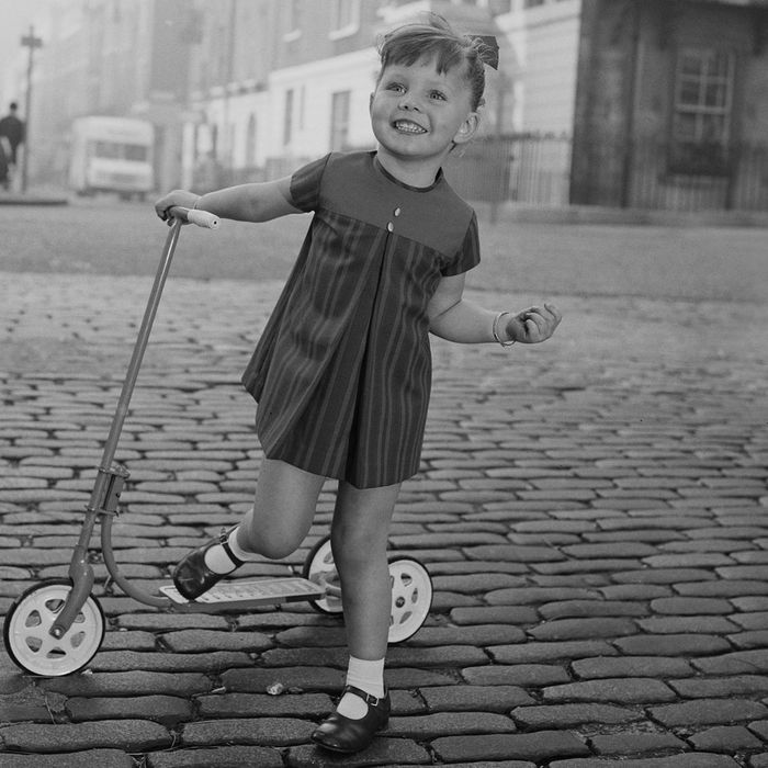 Little girl with a scooter on a cobblestone street — The Strategist reviews the best scooters for kids