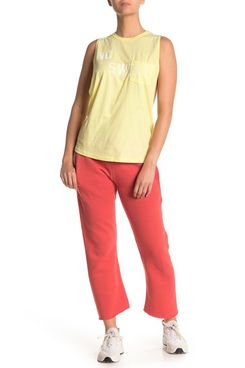 Free People Movement Reyes cropped orange-pink sweatpants, white sneakers, and a yellow tank top with “No Sweat” in whit block letters. 33 Things on Sale You’ll Actually Want to Buy: From Adidas to Le Creuset - The Strategist