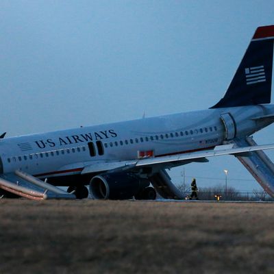A damaged US Airways jet lies at the end of a runway at the Philadelphia International Airport, Thursday, March 13, 2014, in Philadelphia. Airline officials said the flight was heading to Fort Lauderdale, Fla., when the pilot was forced to abort takeoff around 6:30 p.m., after the front landing gear failed. An airport spokeswoman said no injuries have been reported. (AP Photo/Matt Slocum)