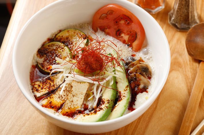 Spicy vegetarian ramen with soy milk, avocado, zucchini, tofu, mushrooms, tomato, and scallion.