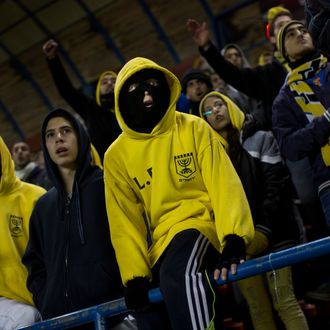 In this Tuesday, Jan. 29, 2013 photo Beitar Jerusalem F.C. soccer supporters watch a State Cup soccer match against Maccabi Umm al-Fahm F.C. at the Teddy Stadium in Jerusalem. Beitar has long tried to quell a tight-knit group that calls itself 