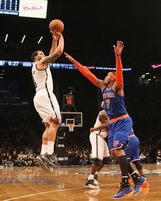 Deron Williams #8 of the Brooklyn Nets sends a shot over Carmelo Anthony #7 of the New York Knicks at the Barclays Center on November 26, 2012 in the Brooklyn borough of New York City. 