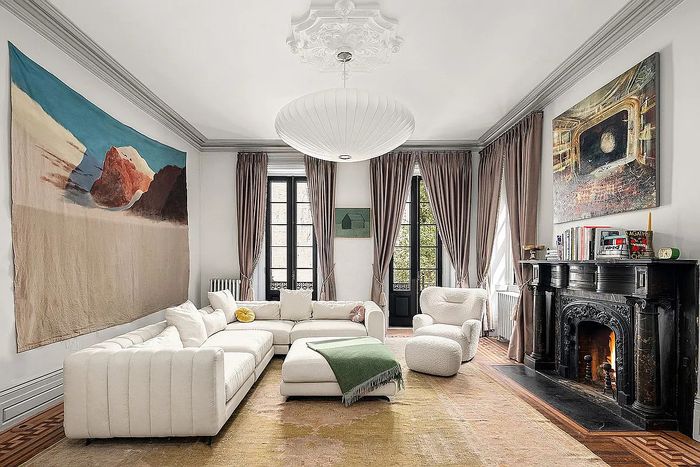 A listing photo showing couch and windows in a living room area