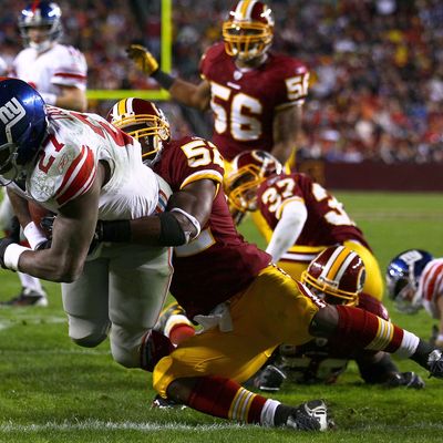 Brandon Jacobs #27 of the New York Giants drags Washington Redskins linebacker Rocky McIntosh into the end zone while scoring a touchdown during their game at FedEx Field on January 2, 2011.