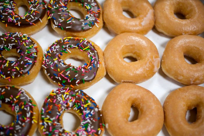 A grid of Krispy Kreme doughnuts, half chocolate sprinkle and half plain