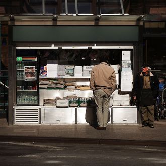 NEW YORK, NY - APRIL 03: Jerry Delakas, 63, (R) a longtime newspaper vendor in Manhattan's Cooper Square, stands by his newsstand on April 3, 2012 in New York City. Delakas has been selling papers, magazines, lottery tickets and other items seven days a week for 25 years at the iconic New York location. Despite the license holder for the newsstand leaving it to him in her will, Delakas is being threatened with eviction by the Department of Consumer Affairs. The New york agency claims that he's not the legal license holder. The area around Astor Place at Lafayette Street, once the heart of bohemian New York, has slowly evolved into an area of banks and chain stores like Starbucks and The Gap. Critics of the city's threat to evict Delakas say that he represents some of the last traces of authentic New York. (Photo by Spencer Platt/Getty Images)