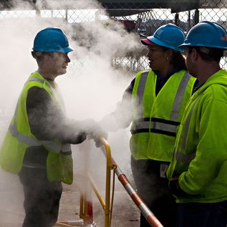 John Shammah, a Con Edison employee, speaks to co-workers while working on a steam pipe on First Avenue on October 31, 2012 in New York City. Residents and businesses across the eastern seaboard are attempting to return to their daily lives and normal operations as clean-up from Hurricane Sandy continues. 